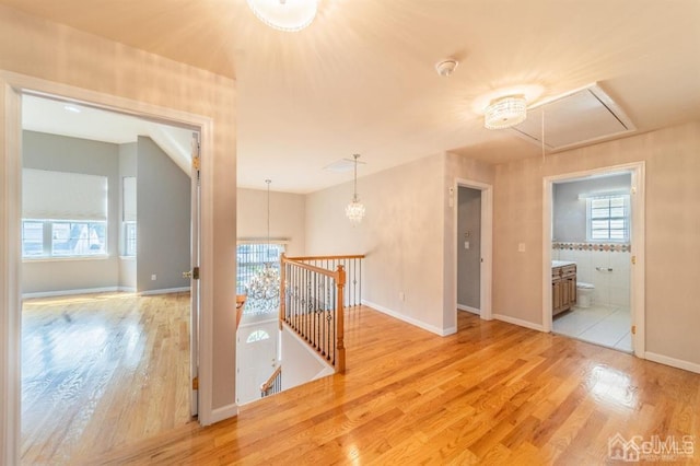 58 S Whittier St, Carteret, NJ 07008 - hall featuring attic access, an upstairs landing, baseboards, a notable chandelier, and light wood-style flooring
