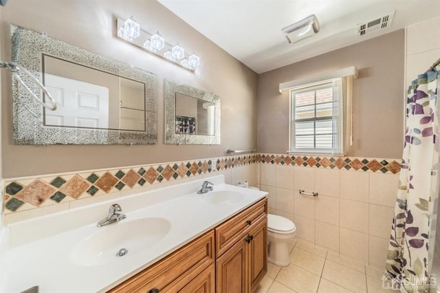 58 S Whittier St, Carteret, NJ 07008 - bathroom featuring visible vents, a sink, toilet, and tile walls