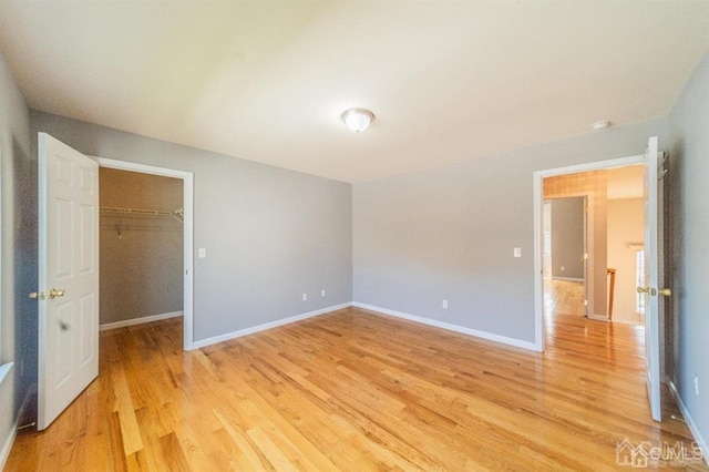 58 S Whittier St, Carteret, NJ 07008 - unfurnished bedroom featuring baseboards, a walk in closet, light wood finished floors, and a closet