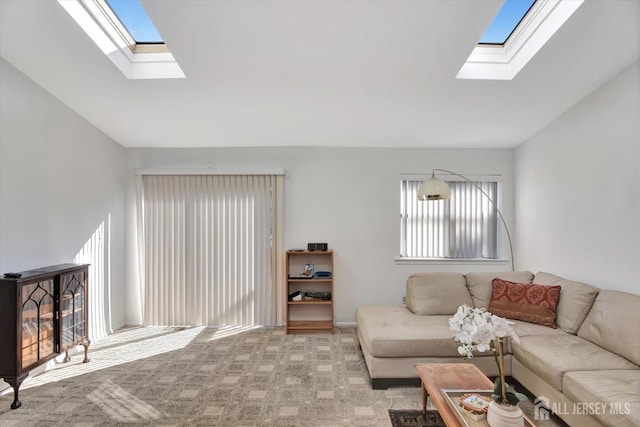 living area with vaulted ceiling with skylight and light carpet