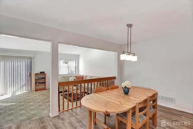 dining room featuring visible vents, baseboards, and wood finished floors