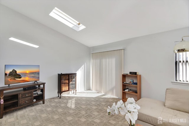 carpeted living area featuring high vaulted ceiling and a skylight