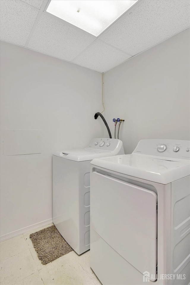 laundry room featuring laundry area, washing machine and dryer, and baseboards