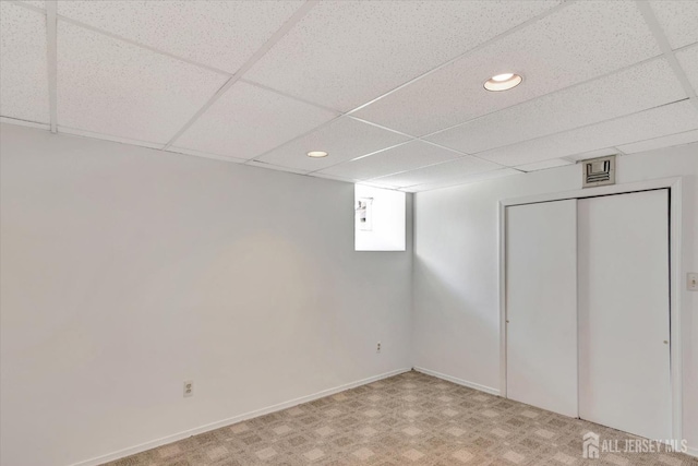 below grade area featuring a drop ceiling, visible vents, baseboards, and recessed lighting