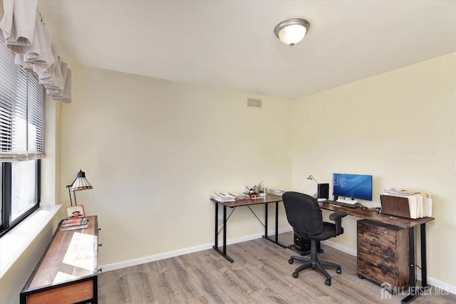 office space with visible vents, baseboards, and wood finished floors