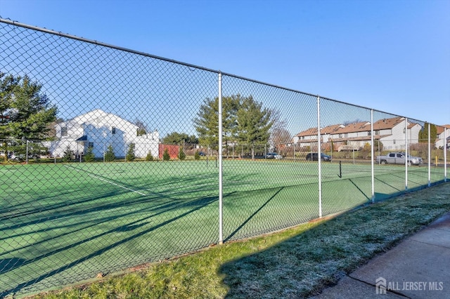 view of tennis court featuring fence