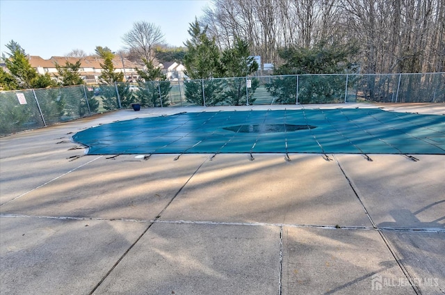 pool with a patio area and fence