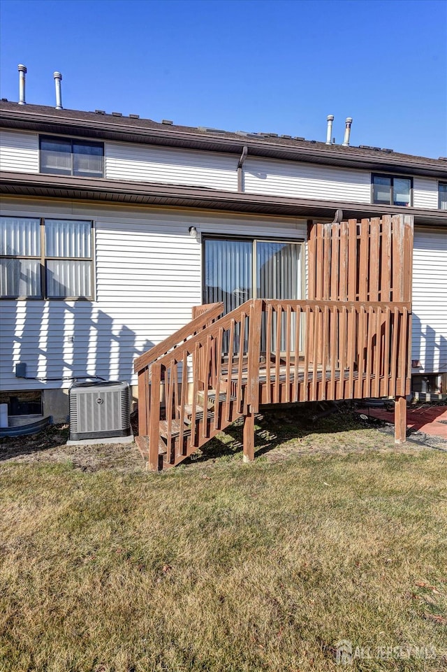 rear view of property with a deck, a yard, and central AC unit