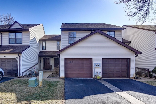 view of front of property with aphalt driveway, an attached garage, and roof with shingles