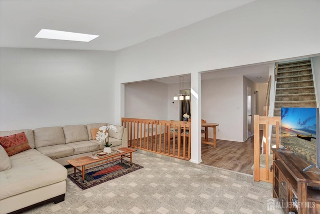 living area featuring vaulted ceiling with skylight and carpet floors