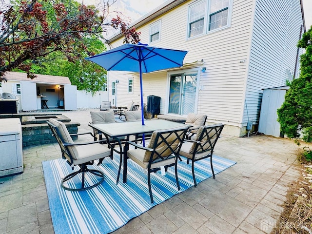 view of patio / terrace featuring outdoor dining area and an outbuilding