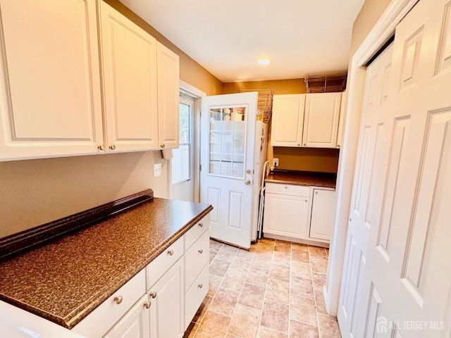 kitchen featuring dark countertops, white cabinetry, and recessed lighting