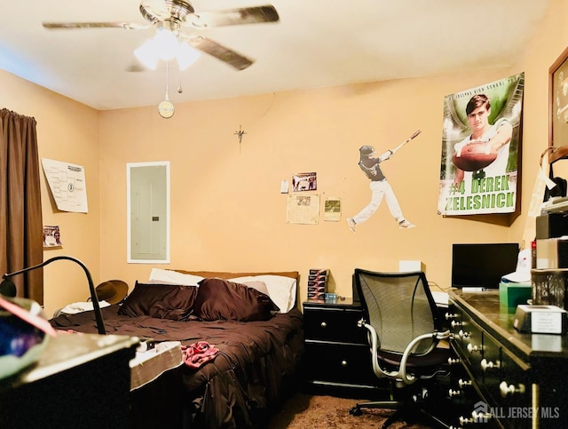 bedroom with electric panel, an office area, and a ceiling fan