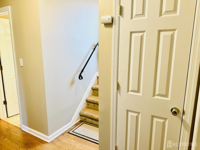 staircase featuring wood finished floors and baseboards