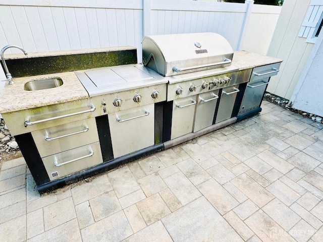 view of patio / terrace featuring a sink, an outdoor kitchen, and grilling area