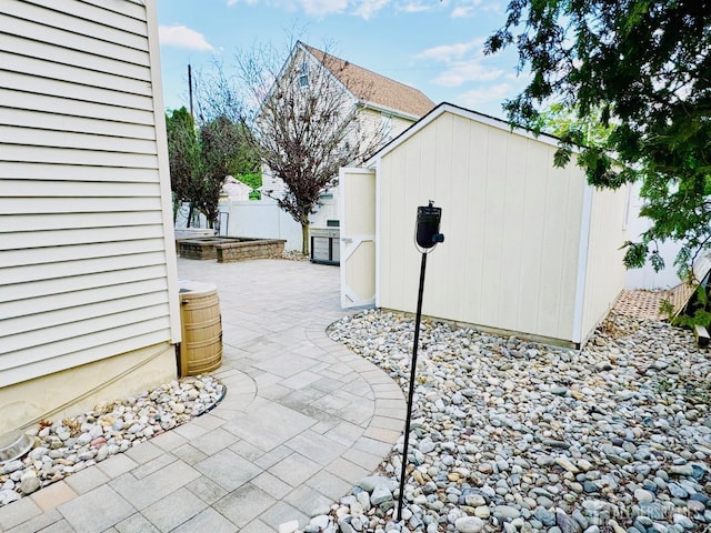 view of patio featuring fence and an outdoor structure