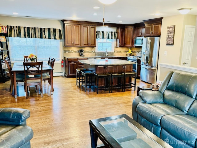 living room featuring light wood-style floors, recessed lighting, and a baseboard radiator
