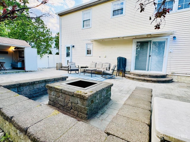 view of patio / terrace with an outdoor living space with a fire pit, fence, and entry steps