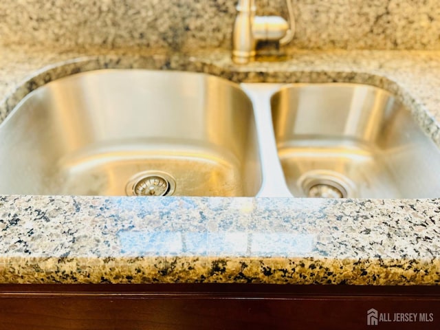 kitchen view of a sink and light stone counters