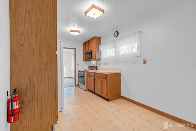 49 Charles Ter, Piscataway, NJ 08854 - kitchen featuring white gas stove, black microwave, light countertops, brown cabinets, and a textured ceiling