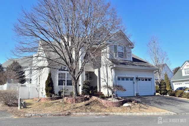 view of front of home featuring driveway and fence