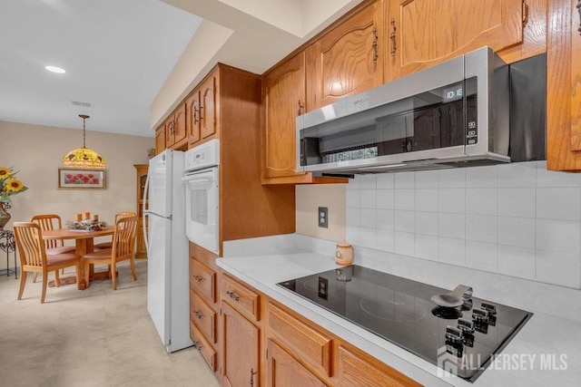 539 Old Nassau Rd Unit B, Monroe, NJ 08831 - kitchen with white appliances, light countertops, backsplash, brown cabinets, and pendant lighting