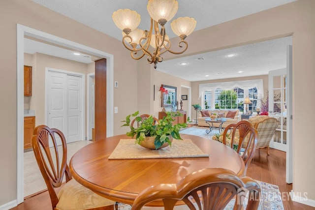 539 Old Nassau Rd Unit B, Monroe, NJ 08831 - dining area featuring light wood-style floors, a chandelier, and a textured ceiling