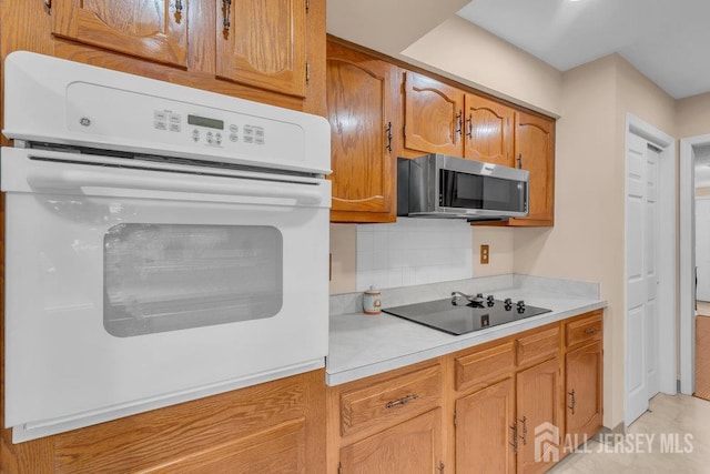 539 Old Nassau Rd Unit B, Monroe, NJ 08831 - kitchen featuring stainless steel microwave, black electric cooktop, white oven, light countertops, and brown cabinetry