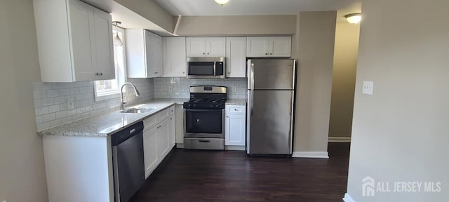 110 Jefferson St, Perth Amboy, NJ 08861 - kitchen with stainless steel appliances, light stone counters, dark wood-style floors, and white cabinetry