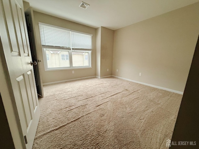 carpeted empty room with visible vents and baseboards