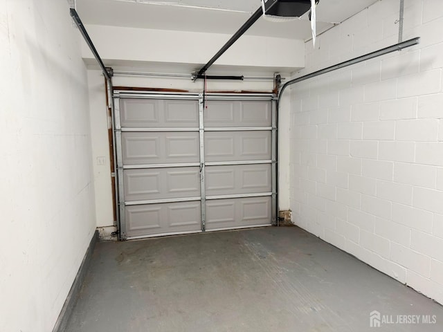 garage with concrete block wall and a garage door opener