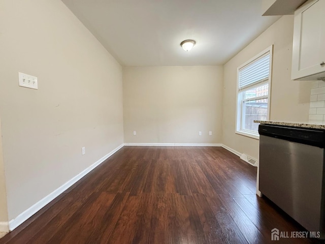 unfurnished dining area with baseboards, visible vents, and dark wood-type flooring