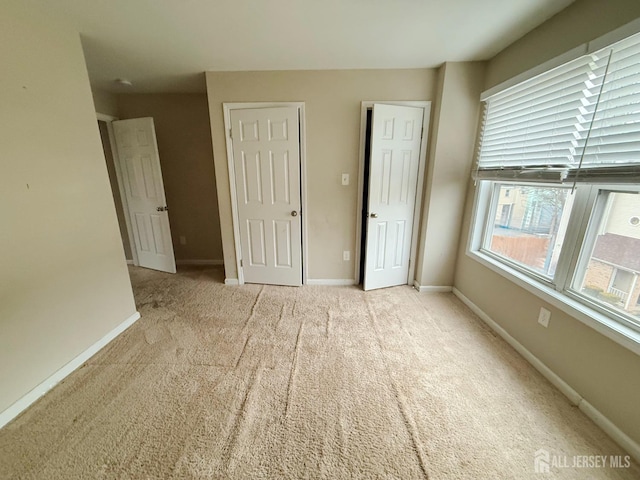 unfurnished bedroom featuring baseboards and carpet