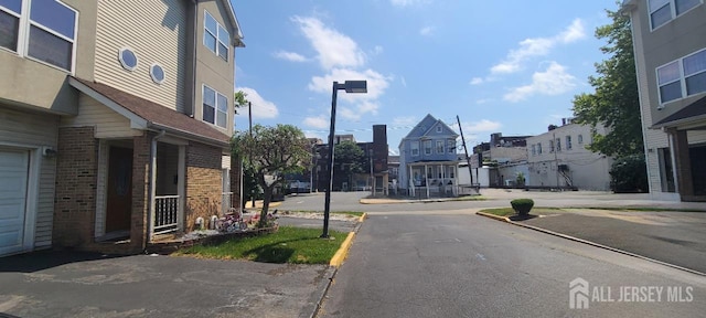 110 Jefferson St, Perth Amboy, NJ 08861 - view of asphalt road featuring curbs, a residential view, and street lights