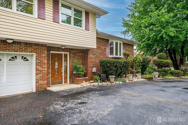 878 Beatrice Pkwy, Edison, NJ 08820 - property entrance featuring brick siding, driveway, a garage, and cooling unit