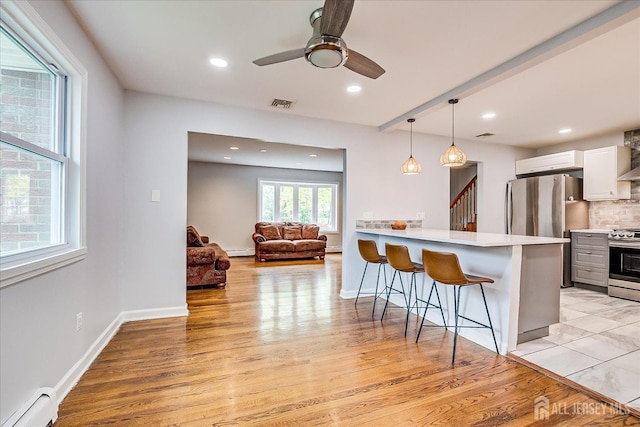 878 Beatrice Pkwy, Edison, NJ 08820 - kitchen featuring stainless steel appliances, a kitchen breakfast bar, baseboard heating, light wood-type flooring, and recessed lighting