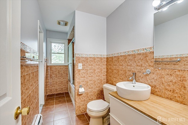 878 Beatrice Pkwy, Edison, NJ 08820 - bathroom with tile walls, tile patterned floors, toilet, baseboard heating, and wainscoting