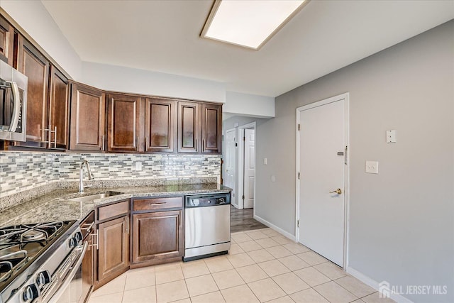 922 Thomas Ave, North Brunswick, NJ 08902 - kitchen featuring stainless steel appliances, a sink, tasteful backsplash, light stone countertops, and light tile patterned floors