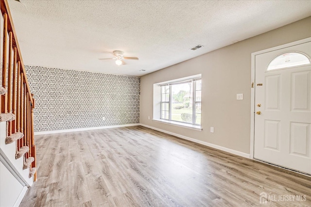 922 Thomas Ave, North Brunswick, NJ 08902 - entrance foyer featuring baseboards, wood finished floors, a ceiling fan, wallpapered walls, and a textured ceiling