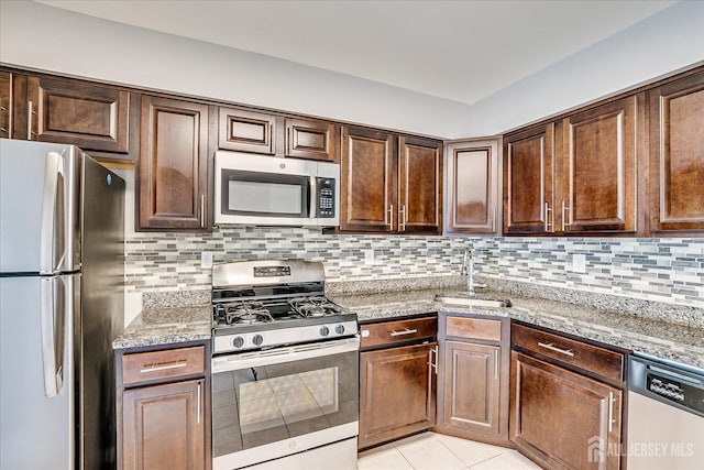 922 Thomas Ave, North Brunswick, NJ 08902 - kitchen featuring stainless steel appliances, a sink, light stone counters, backsplash, and light tile patterned floors