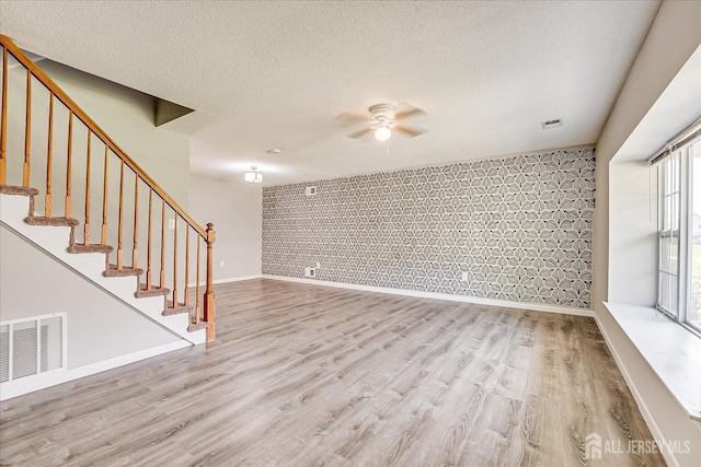 922 Thomas Ave, North Brunswick, NJ 08902 - unfurnished living room with a ceiling fan, wood finished floors, baseboards, stairway, and a textured ceiling