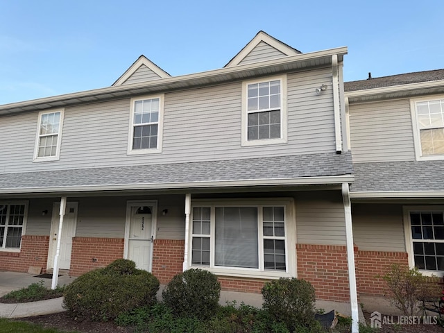 townhome / multi-family property featuring brick siding and a shingled roof