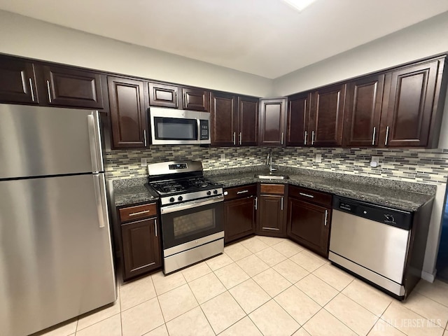 kitchen with tasteful backsplash, dark brown cabinetry, stainless steel appliances, and light tile patterned flooring