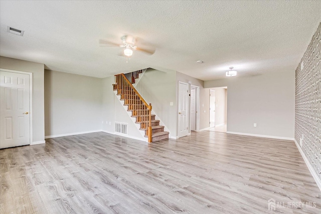 922 Thomas Ave, North Brunswick, NJ 08902 - unfurnished living room featuring wood finished floors, stairs, a ceiling fan, baseboards, and a textured ceiling