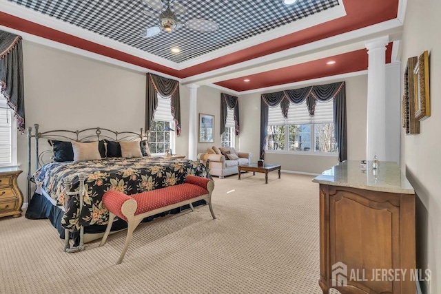 carpeted bedroom with crown molding, decorative columns, and a raised ceiling