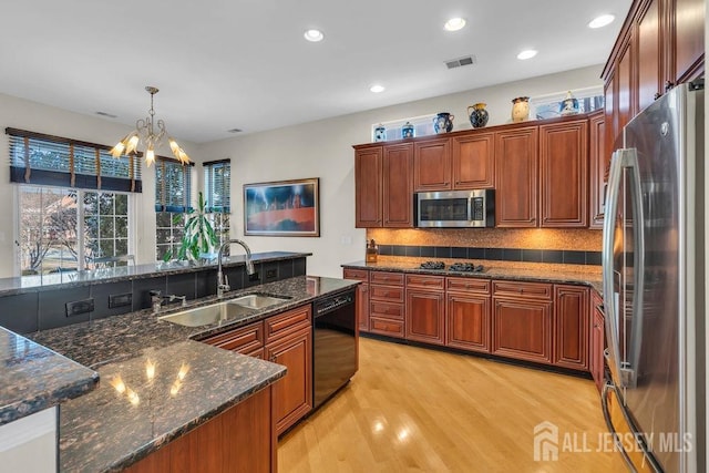 kitchen with pendant lighting, sink, tasteful backsplash, a notable chandelier, and black appliances