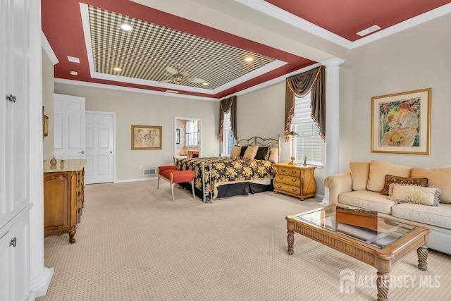 carpeted bedroom featuring crown molding, a raised ceiling, and decorative columns