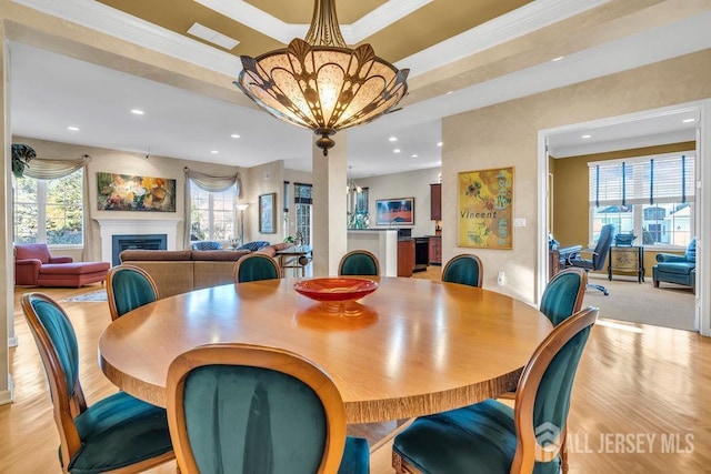 dining room featuring a raised ceiling, crown molding, a wealth of natural light, and an inviting chandelier