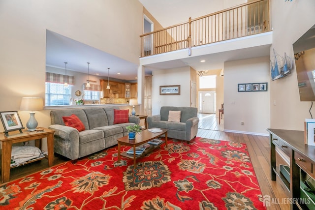 living room featuring light hardwood / wood-style floors and a high ceiling