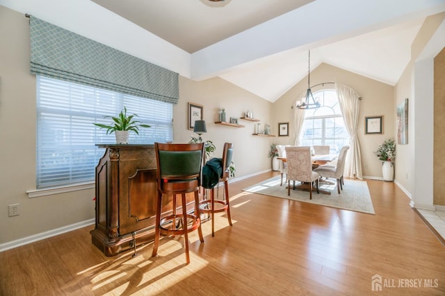 dining area featuring vaulted ceiling, light wood-type flooring, and a notable chandelier